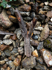rocks left  by pilgrims close to a cross in the forest on the pilgrimage along the road to Santiago in Portugal, Caminho Portugues