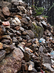 rocks left  by pilgrims close to a cross in the forest on the pilgrimage along the road to Santiago in Portugal, Caminho Portugues