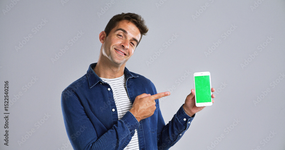 Poster Man, portrait and phone pointing to green screen in studio for website, mockup space and white background. Student person, user or model with smile, smartphone or software app for university schedule