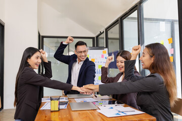 Group of Asian businesspeople Join hands and work together as a team in modern office, Business startup and company strategy planning concept.