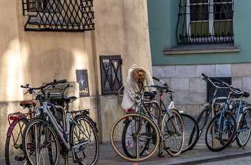 Krakow, Poland - 05 14 2024: A woman unlocking her bicycle after the workday in readiness for the commute home.