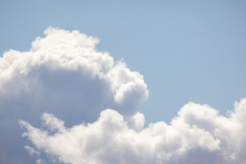 Fluffy white clouds float peacefully against a vibrant blue sky