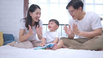 Fototapeta premium Before putting the kids to bed, parents, and kid unwind and play in the bedroom