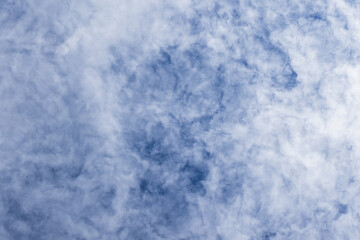 Wispy white clouds against a vibrant blue sky create a serene mood