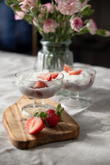 Healthy homemade chia dessert with strawberry and coconut on sunny cozy background 