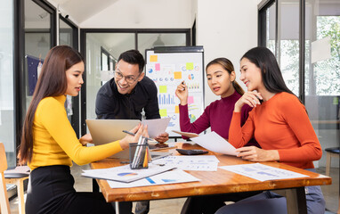 Fototapeta premium Group of Asian business working analysis project brainstorm in modern office, Asian businesspeople team working together, Business startup and company strategy planning concept.