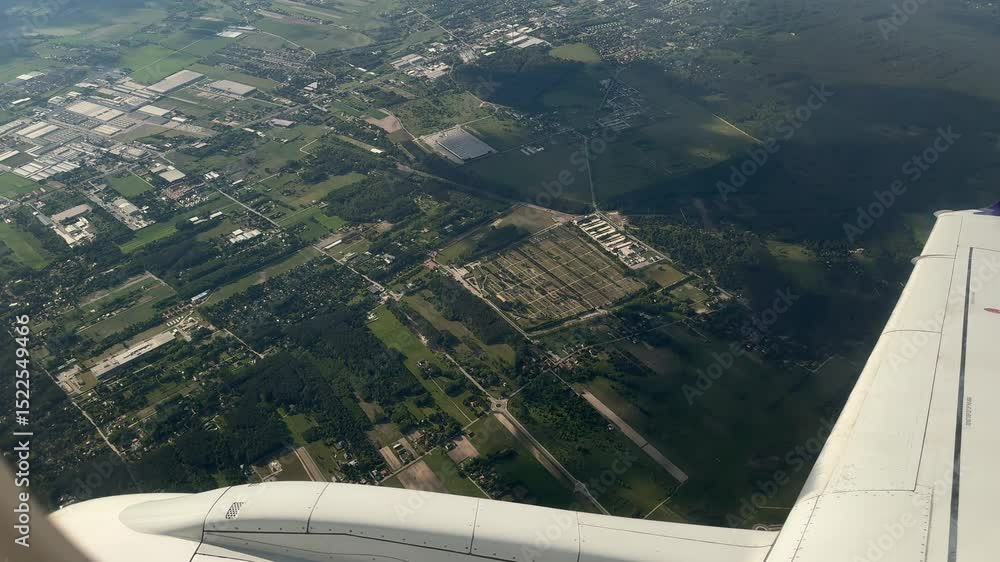 Poster view from airplane window over green fields and buildings during descent near wroclaw in sunny weath
