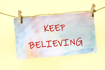 Business concept. Copy space. Concept Words KEEP BELIEVING written on a colorful sign on a rope...
