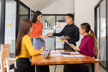 Group of Asian business people holding laptop computer working together and presentation a meeting in office, Business person group and new idea project creative concept.