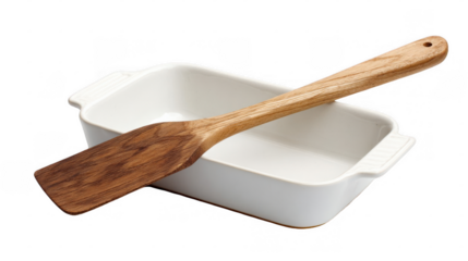 Hand carved wooden spatula leaning against a clean white empty baking dish, isolated on transparent background, ready for cooking and baking