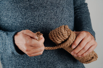 man pulling rope from a tangled coil