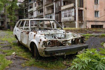 The body of a dismantled abandoned car in the courtyard of a residential building. Abandoned mining village of Akarmara