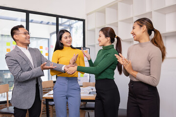 Obraz premium Group of Asian businesspeople talking together and brainstorm standing in modern office, Business startup and company strategy planning concept.
