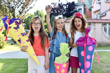 Happy little children with sweets in a cone on the first day of school. Back to school