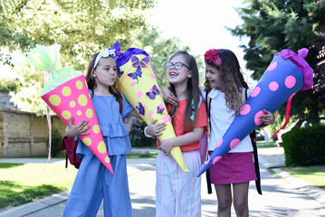 Happy little children with sweets in a cone on the first day of school. Back to school