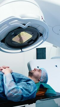 Vertical Video. A patient undergoing radiation therapy. Medical linear accelerator in therapeutic oncology. The concept of modern approaches to the treatment of oncology.