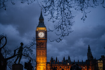 Illuminated Big Ben at Dusk with Silhouetted Trees