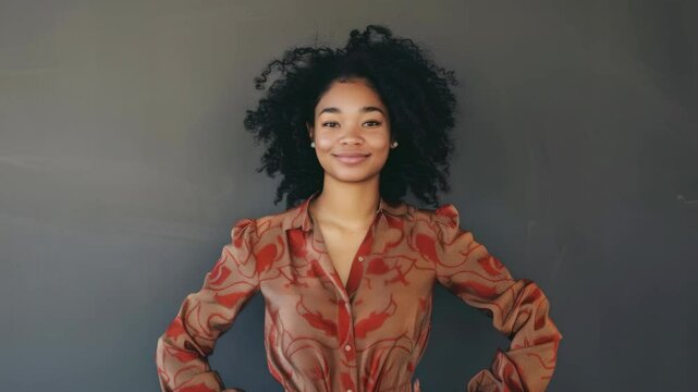 A woman in a red patterned blouse and pants, posing against neutral backdrop.