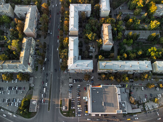 Aerial top view of city streets with multiple lanes, road markings, and cars navigating residential district