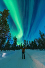 Man standing under northern lights in the arctic circle
