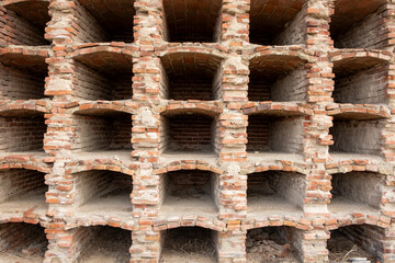 Ancient niches for housing the remains of the deceased, built with bricks, empty, in a cemetery.