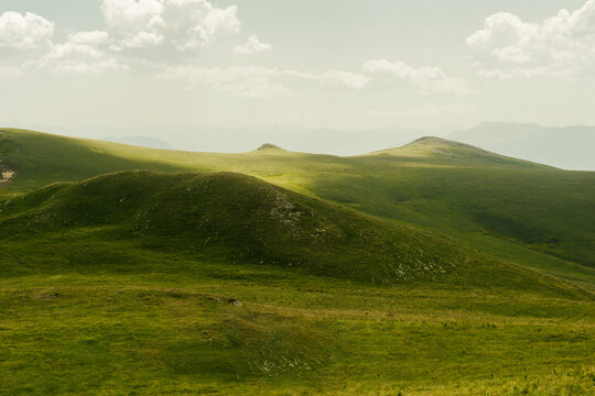 Mountain landscape with soft green hills and distant forested ridges