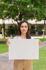 woman holding a blank sign in park