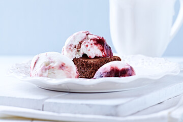 Strawberry ice cream with chocolate and cherry syrup on chocolate brownie. Selective focus.	