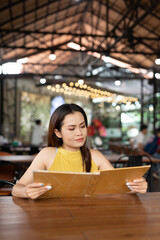 woman in restaurant reading menu