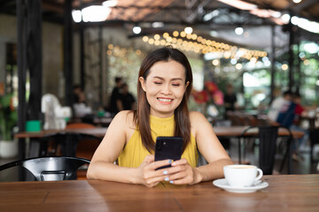Woman in cafe using mobile phone