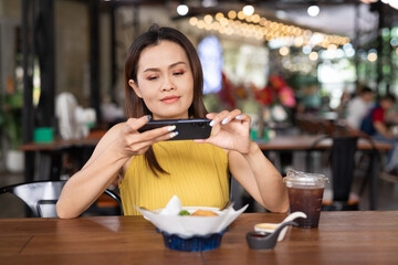 Foodie woman in cafe taking photo with mobile phone