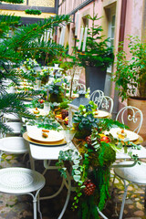 Served table for many quests on inner yard with traditional half-timbered house, Strasbourg, France