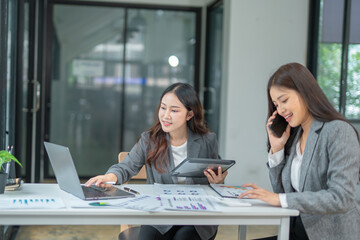  Two businesswoman hands or accountants working together on financial investment on calculator, calculating, analyzing business growth and marketing on graph.