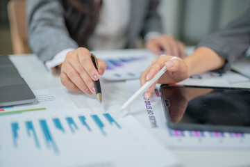 Business team working in office with graph documents on desks, planning, analyzing financial...