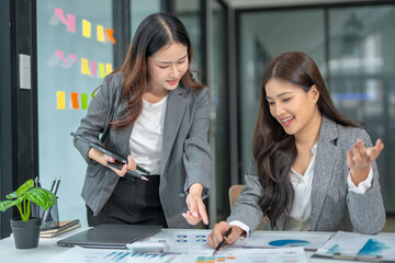 Two businesswoman hands or accountants working together on financial investment on calculator, calculating, analyzing business growth and marketing on graph.