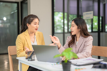 Two businesswoman hands or accountants working together on financial investment on calculator, calculating, analyzing business growth and marketing on graph.