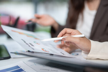Business team working in office with graph documents on desks, planning, analyzing financial reports in conference room, brainstorming, discussing and analyzing business strategies.