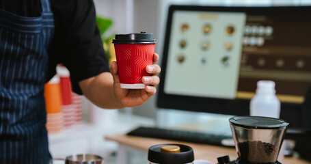 Barista pouring milk into cappuccino, creating latte art in cozy café setting, showcasing morning preparation, craftsmanship, and coffee culture indoors.