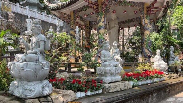 Tang Chon Cave, Marble Mountain Vietnam stunning. pagoda perched on a rocky cliff surrounded by lush green hills and a rural landscape in the distance.