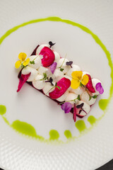 Colorful beetroot slices with goat cheese, garnished with edible flowers
