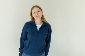 Pretty smiling joyfully female, dressed casually, looking with satisfaction at camera, being happy. Studio shot of beautiful woman isolated against blank studio wall.