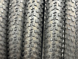 Close-up of a bicycle tire texture, detailed view of rubber pattern and tread design, showcasing durability, grip and traction for cycling and mountain biking. Black rubber texture on white background