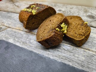 Freshly baked bread with wheat on a rustic wooden table next to a cutting board