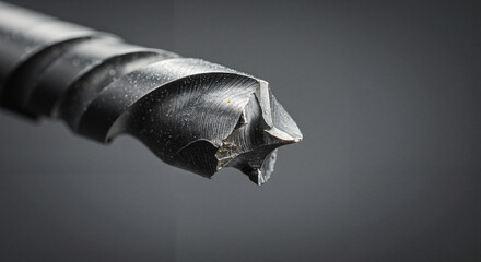 Close-up of metal drill bit against dark background  