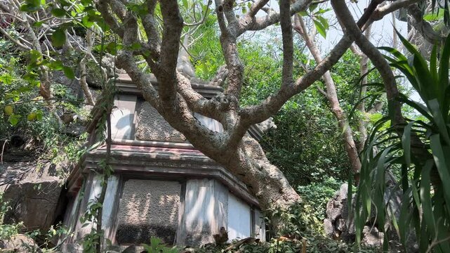 Tang Chon Cave, Marble Mountain Vietnam stunning. pagoda perched on a rocky cliff surrounded by lush green hills and a rural landscape in the distance.