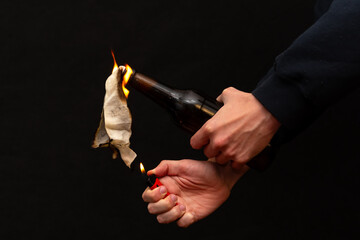 An image of street warfare and anarchy using a flammable mixture in a bottle.