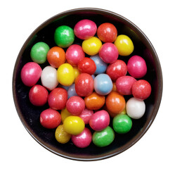 Top view of a dark bowl filled with colorful candy-coated chewing gum balls in various bright colors, isolated on a transparent background