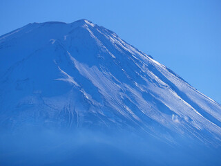 Snow-covered slopes of Mount Fuji on a clear sunny day