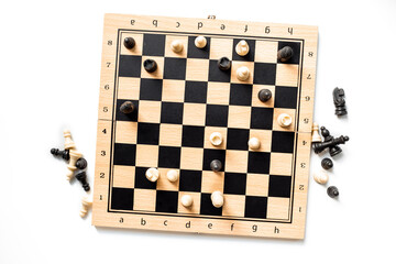 White and black chess pieces on chessboard during the game, top view