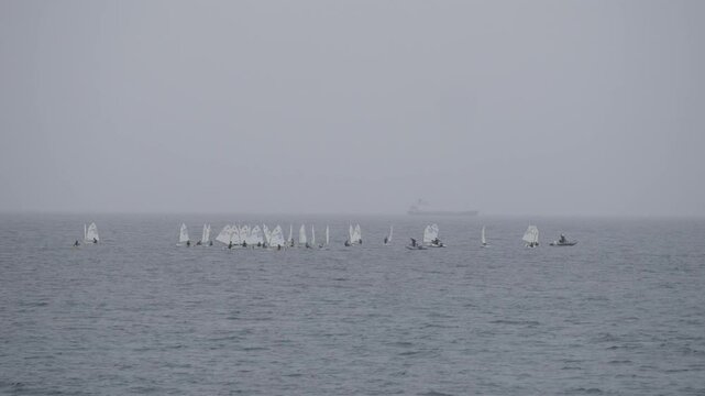 Group of children sailing small Optimist boats during training on open water